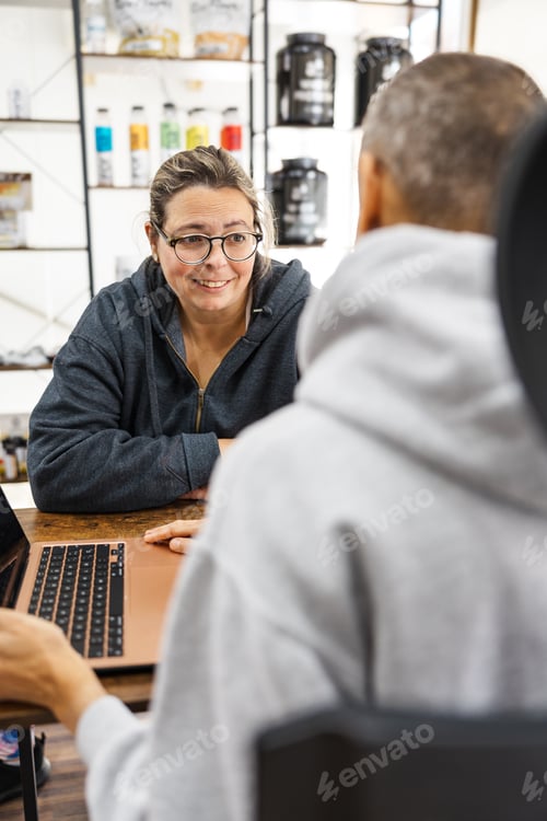 Preview: Nutritionist giving advice to client using laptop in office