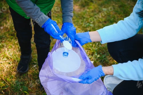 Preview: Woman volunteer and little boy picking up the plastic garbage