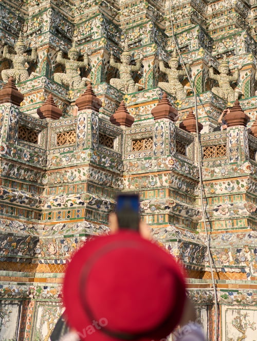 Preview: thai woman taking photo with smartphone of wat arun temple in bangkok thailand