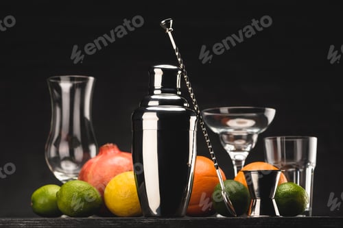 Preview: shaker for preparing alcohol drink and empty glasses on table isolated on black