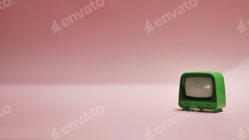 Preview: Closeup of a small green vintage TV toy isolated on a light pink background