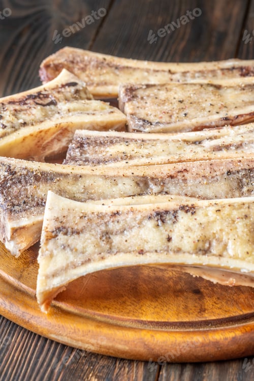 Preview: Rustic roasted marrow bones rest on warm wooden board, savory richness revealed
