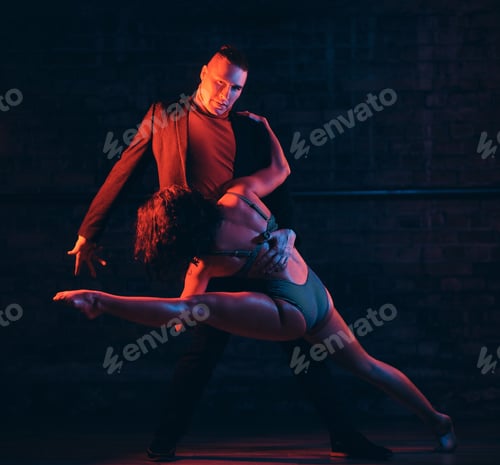 Preview: Beautiful couple dancing in a night club. Dancers performing in the dark with illumination