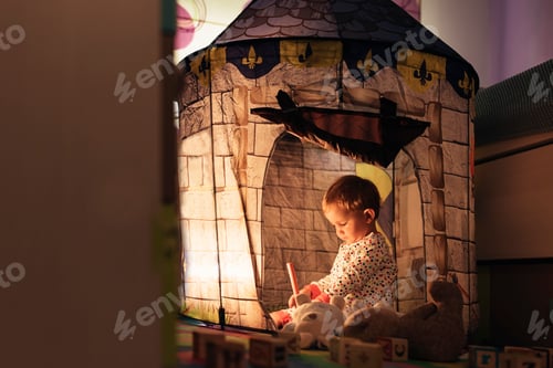 Preview: Little boy playing into castle toy at home.