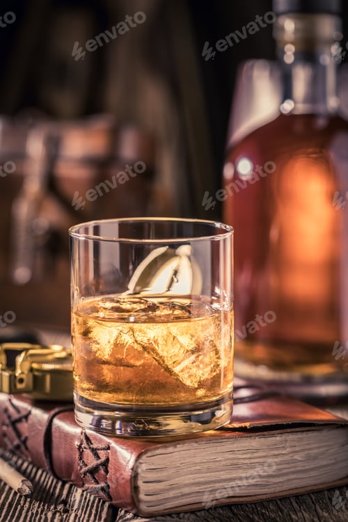 Preview: Gold whisky with ice on old journal