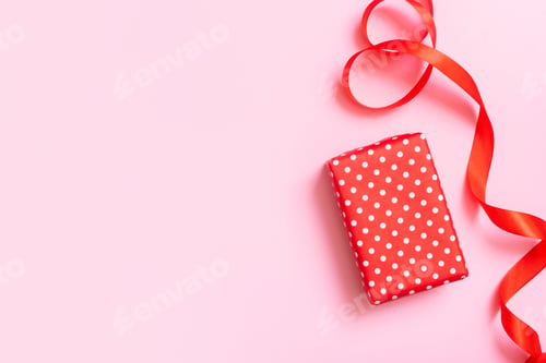Preview: Christmas present flat lay on a pink background. Top view xmas gift box with decorations