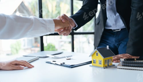 Preview: Agent and client shaking hands after signed document and done business deal