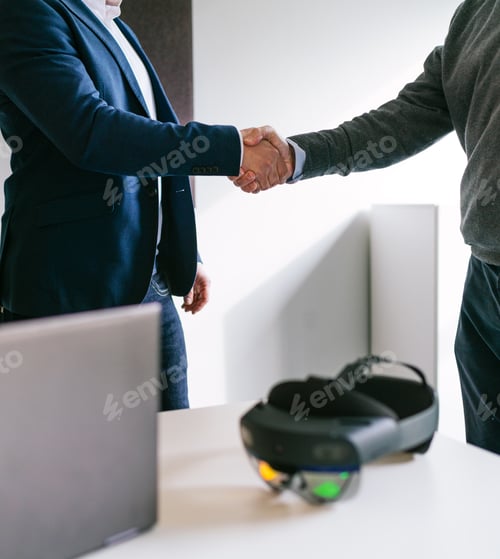 Preview: Close-Up of Handshake Sealing VR Glasses Deal in Office Setting