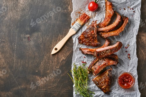 Preview: Grilled and smoked pork ribs with barbeque sauce on an old vintage wooden cutting board. Tasty snack