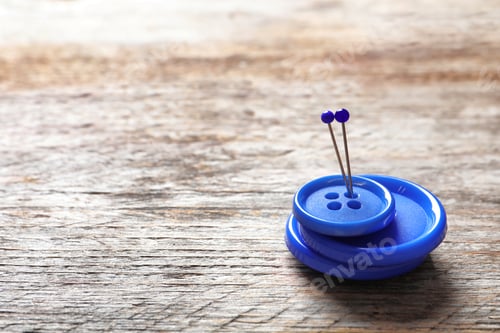Preview: Blue buttons with pins on wooden background. Tailoring equipment