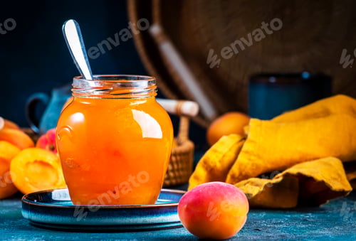 Preview: Sweet Apricot jam or confiture in glass jar with metal spoon and fresh fruits