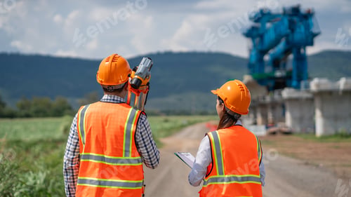 Preview: Survey team is working with a theodolite and road construction plans.