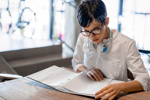 Preview: Portrait of clever student reading book in college library
