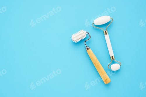 Preview: Set of massage rollers for face on blue background. Skincare concept. Copy space for text, top view