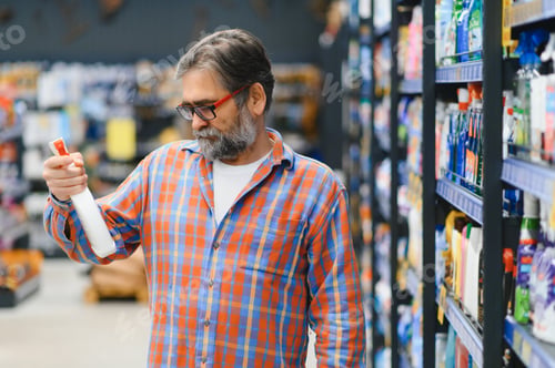 Preview: male customer making purchases in supermarket, buying household chemicals