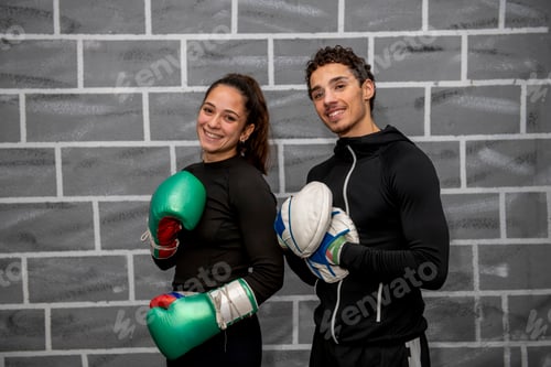 Preview: Boxers smiling and holding boxing gloves in gym posing for photo