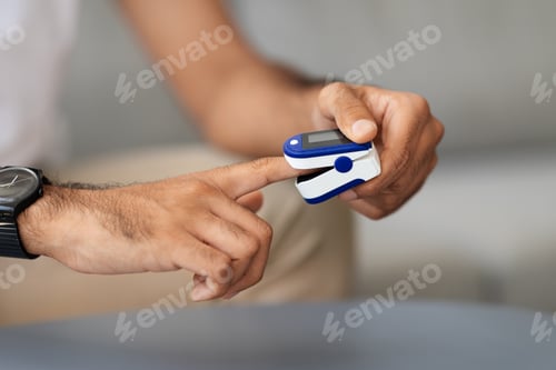 Preview: Unrecognizable man using pulse oximeter, closeup photo