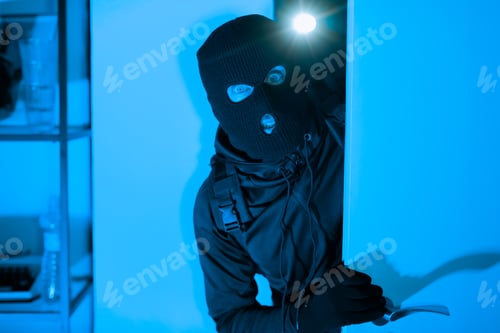 Preview: Burglar with crowbar breaking into a house