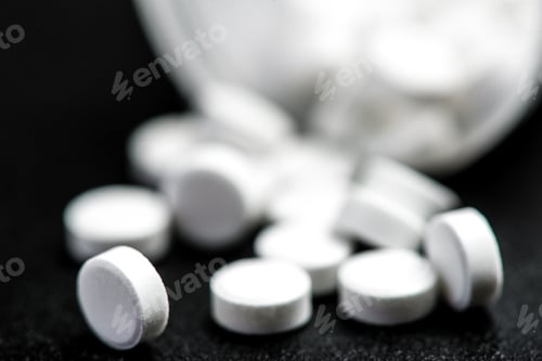 Preview: Medical white pills for the treatment and health care on a black background.