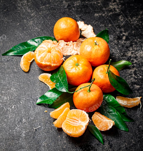 Preview: Ripe tangerines with foliage. On a black background.