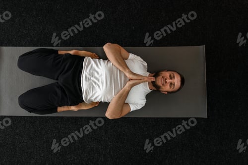 Preview: Professional happy young man doing yoga and happy smiling indoors. Meditation and relax.