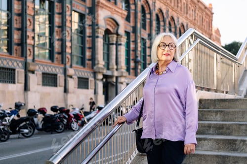Preview: senior woman walking down stairs in the city