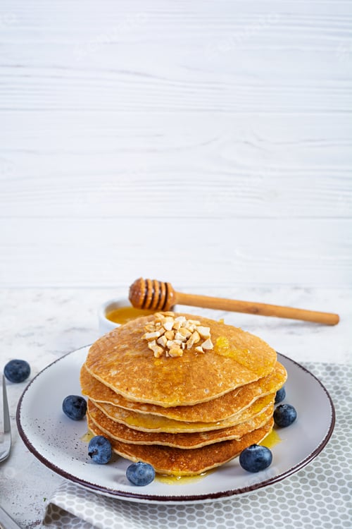 Preview: Delicious homemade pancakes with honey and blueberries. Tasty breakfast with crepes