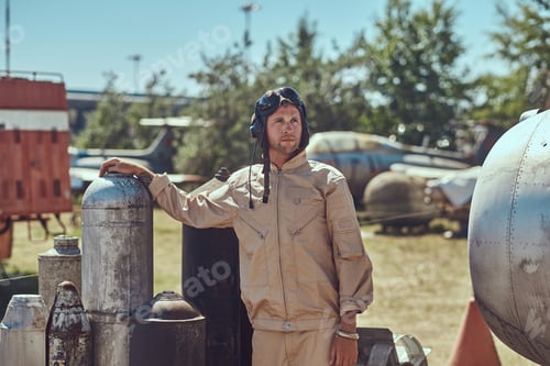 Preview: Mechanic in uniform near to combat bombs for a bomber aircraft in an open-air museum.