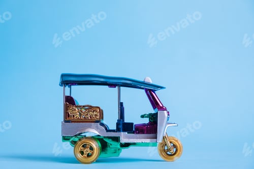 Preview: Model Toy tuk tuk isolated on blue background. Thai traditional taxi in Bangkok Thailand. Souvenir