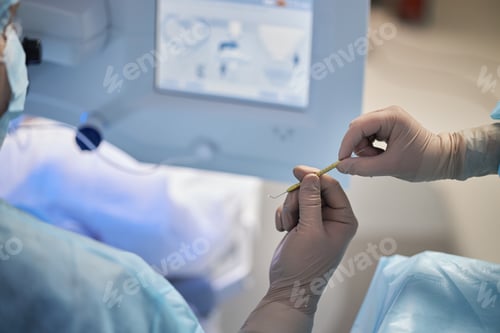 Preview: Male Surgeon Receiving Surgical Instrument from Assistant during Operation