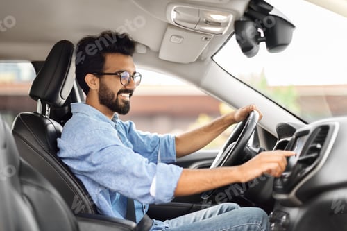 Preview: Happy young indian man driving car and listening to music