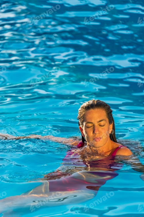 Preview: beautiful tanned young woman in bikini relaxing in pool.