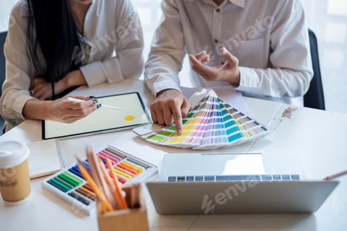 Preview: Close-up. Group of designer working with a tablet and a color sample at the office.