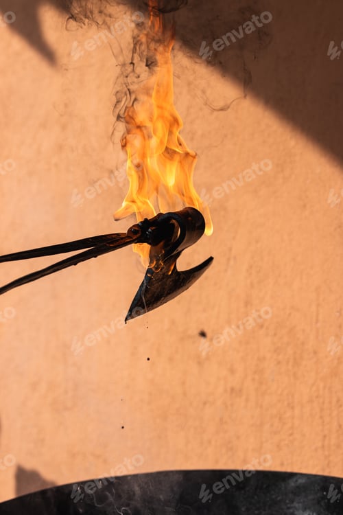Preview: Blacksmith putting hot burning metal viking axe in water
