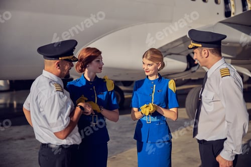 Preview: Happy friendly flight team talking together in the outdoors