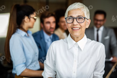 Vista previa: Confident stylish european mature business woman standing at workplace