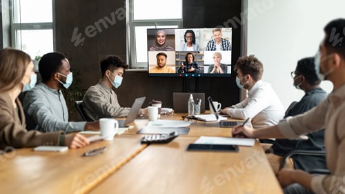 Preview: Diverse businesspeople in masks making online video call to employees