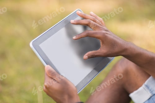 Preview: Handsome hipster using his tablet pc on a sunny day