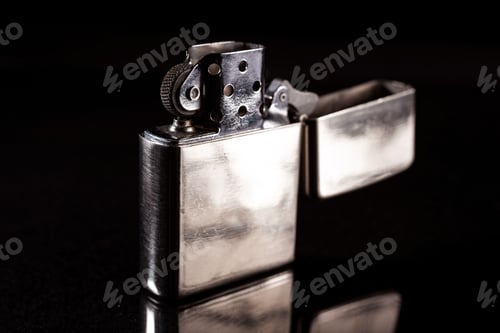Preview: Closeup of an open silver metal lighter isolated on a black reflective background