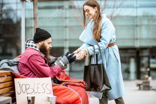 Preview: Woman giving food to a homeless beggar