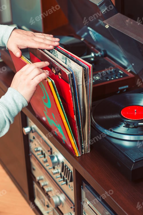 Preview: Man holding bunch of vinyl records. Set of audio equipment, record players, amplifiers, radio
