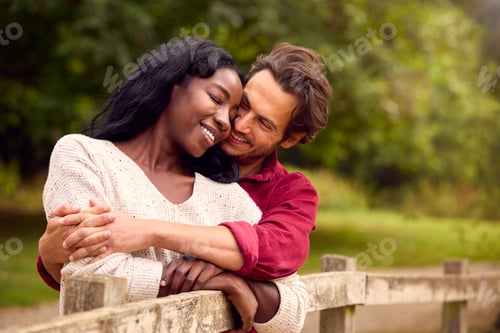 Preview: Loving Mixed Race Couple Leaning On Fence On Walk In Countryside