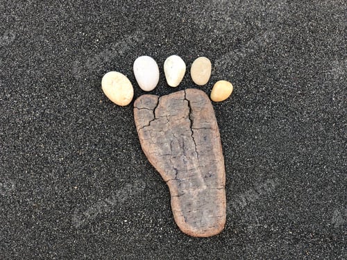 Preview: First step, conceptual artistic composition with pebbles and wood material in form of a foot