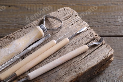 Preview: Set of different clay crafting tools on wooden table, closeup