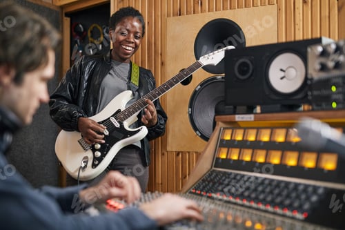 Preview: Young Woman Playing Guitar in Recording Studio
