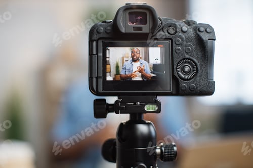 Preview: Close up of digital camera with african blogger on screen