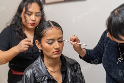 Preview: Two professional makeup artists applying makeup to a client