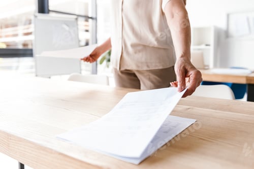 Preview: Close up of mature business woman working with documents