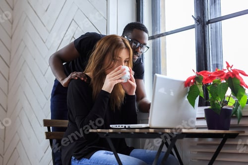 Preview: A woman drinks coffee with black man.