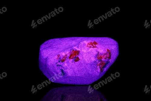 Preview: macro mineral stone spinel under ultraviolet light on a black background background
